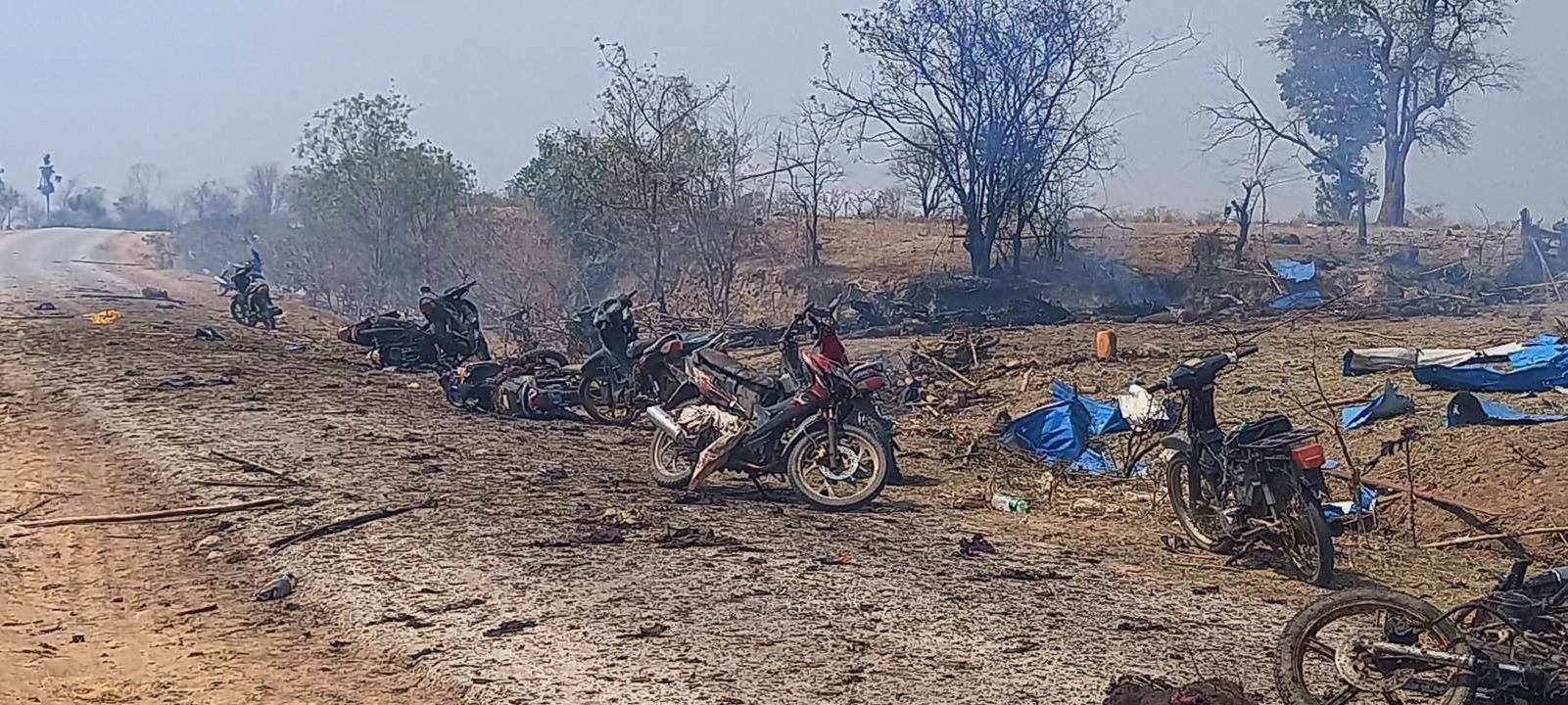 Motorräder stehen in einem qualmenden Feld.