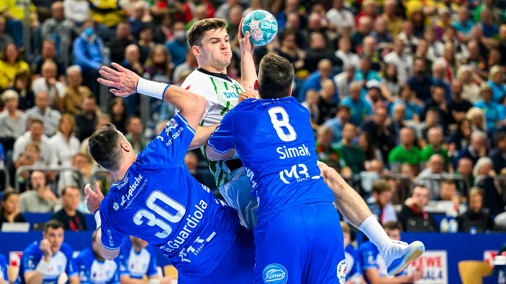 , Kay Smits von SC Magdeburg und Frederik Simak von TBV Lemgo kämpfen um den Ball. Foto: Marco Wolf/dpa +++ dpa-Bildfunk +++