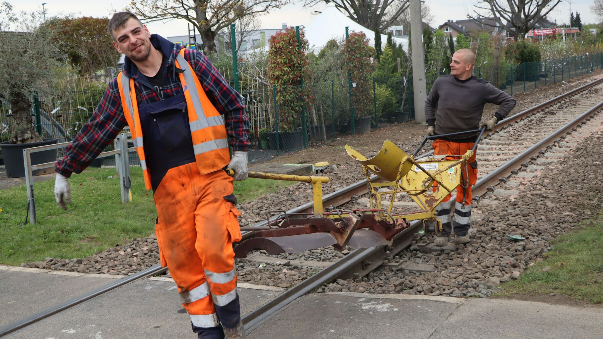 Das Foto zeigt, wie Bauarbeiter nach Abschluss der Arbeiten an der Bahnstrecke zwischen Brühl und Bornheim Material wegräumen.