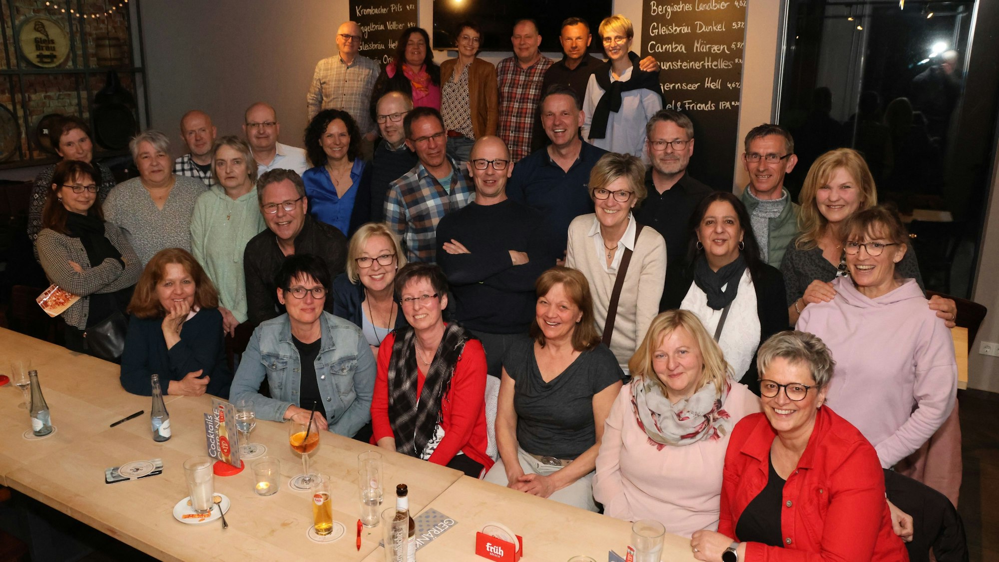 Ein Gruppenfoto mit 49 Leuten in einem Brauhaus.