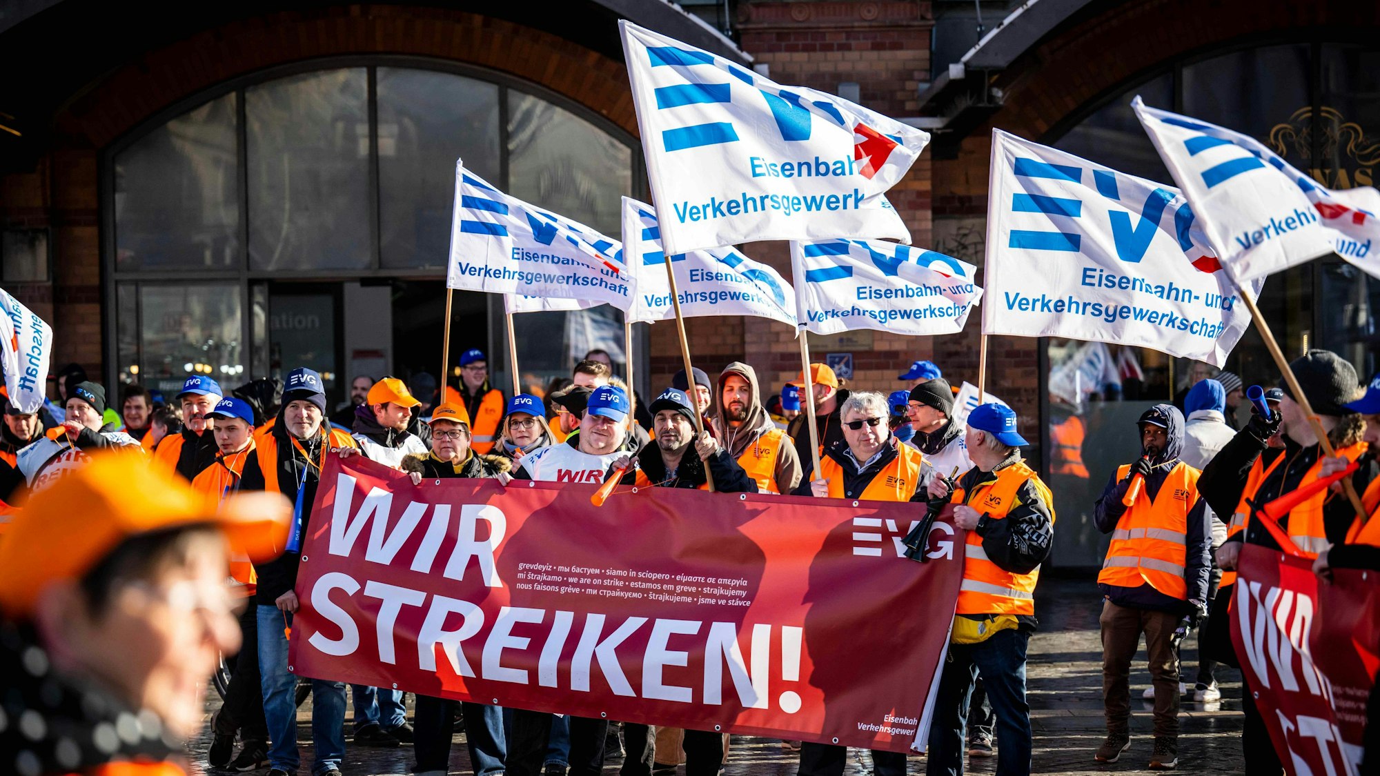 Demonstranten der Eisenbahn- und Verkehrsgewerkschaft (EVG) stehen mit Plakaten vor dem Hauptbahnhof.