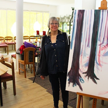 Eine Frau steht neben einem Kunstgemälde