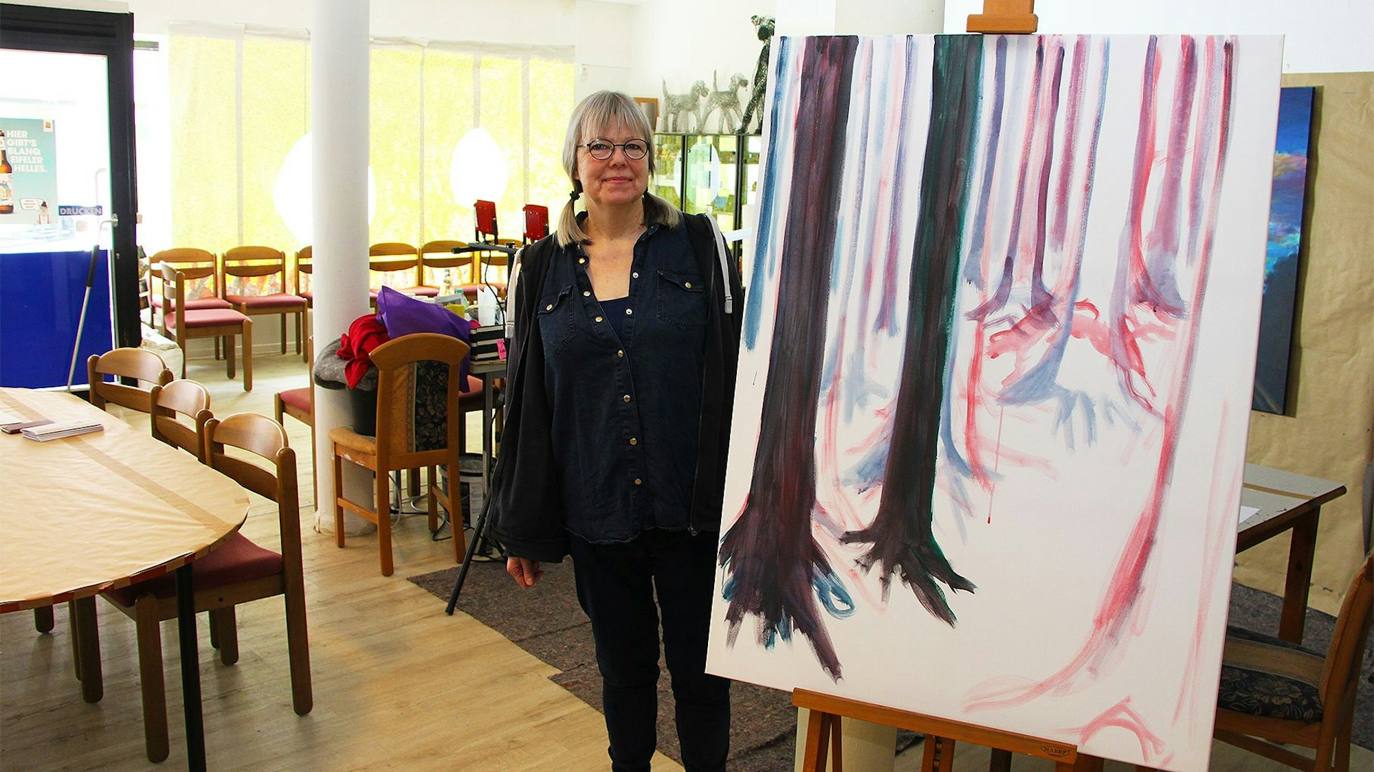 Eine Frau steht neben einem Kunstgemälde