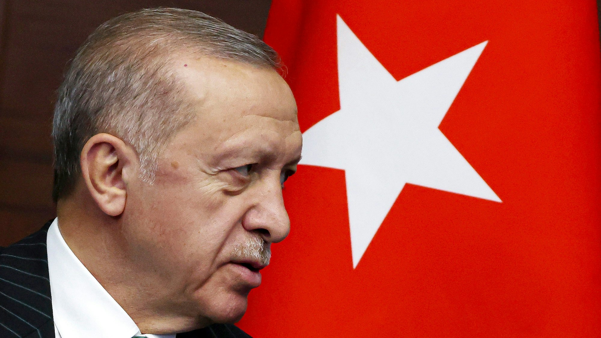 Recep Tayyip Erdogan, Präsident der Türkei, steht neben einer türkischen Flagge