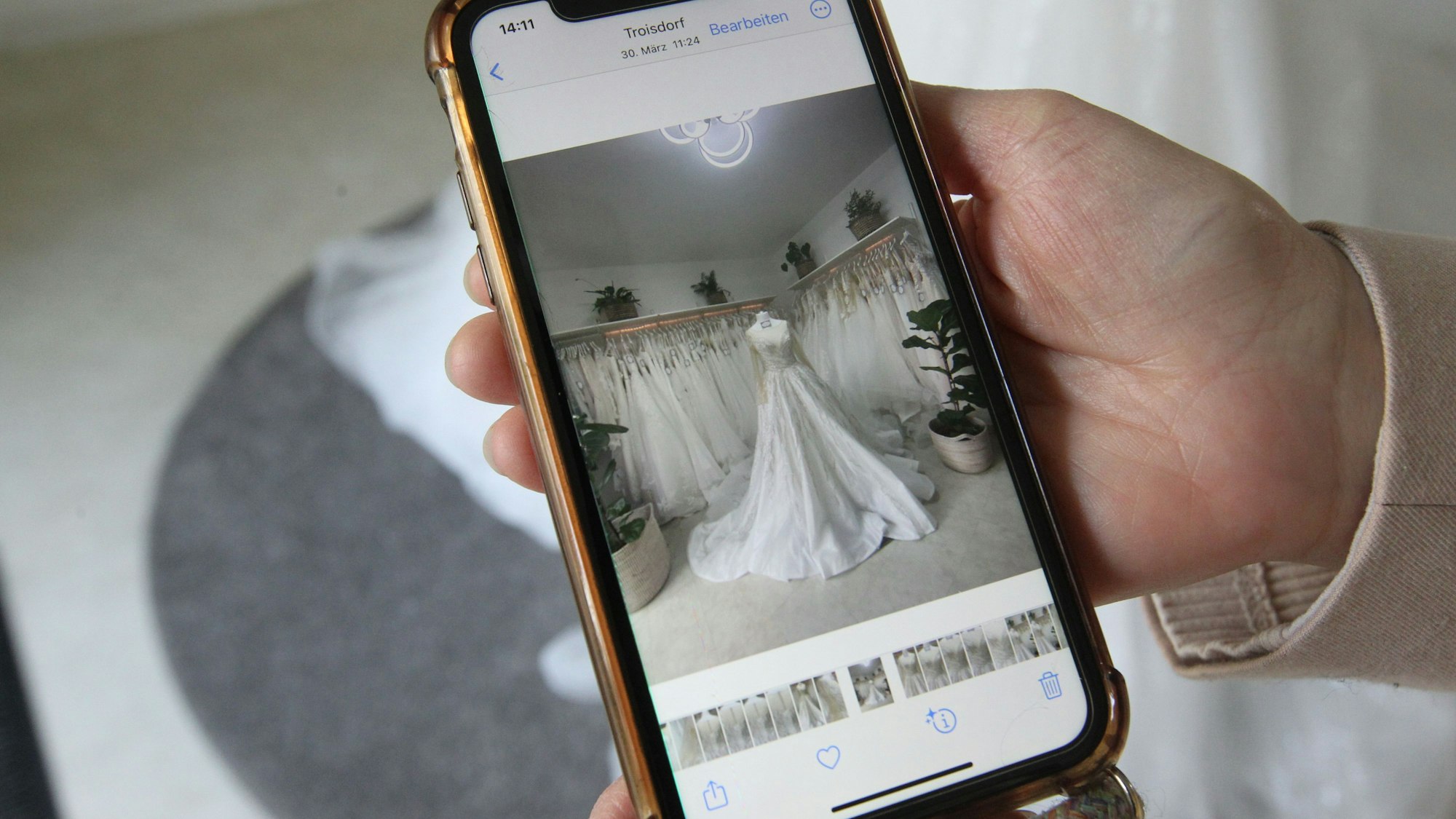 Auf einem Smartphone ist ein Bild von einem Brautkleid zu sehen.