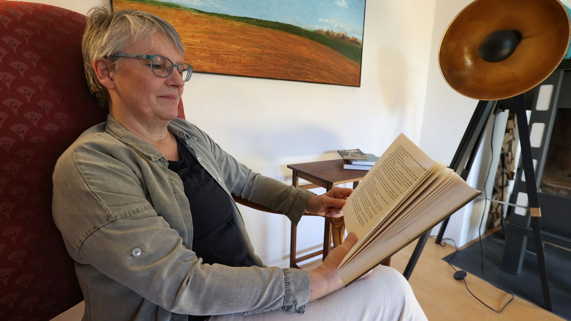 Erika Mager liest in einem ihrer Lieblingsbücher am 14.04.2023 in ihrem Wohnzimmer in Alfter. Foto Copyright: Petra Reuter