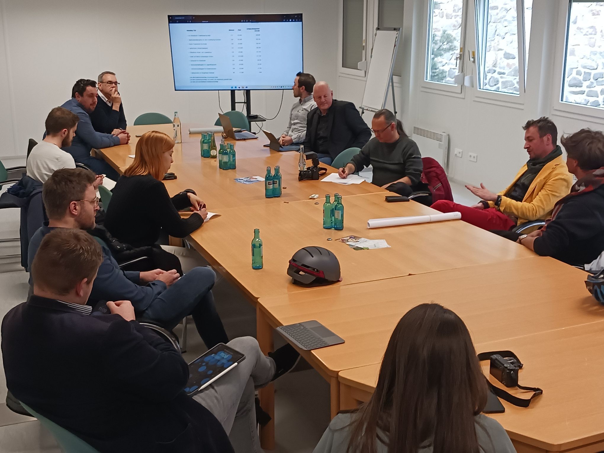 Menschen sitzen an einem Tisch und diskutieren.