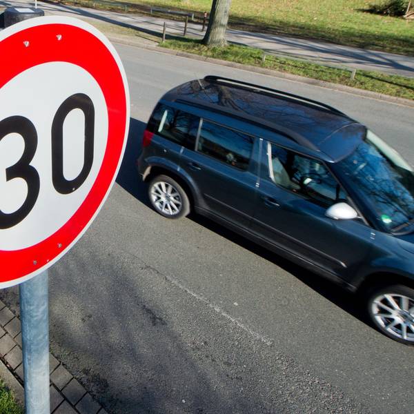 Ein Auto fährt an einem Verkehrsschild für eine Geschwindigkeitsbegrenzung von 30 Stundenkilometer vorbei.