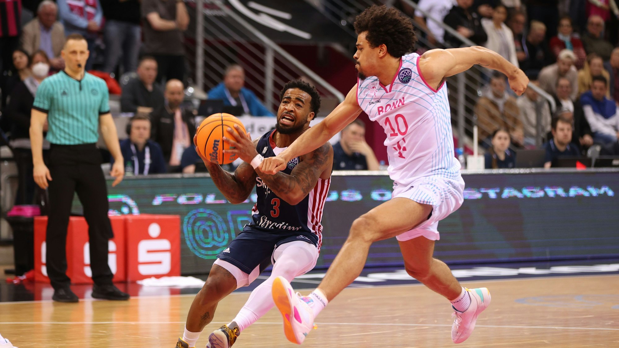 Marcus Keene (Strasbourg) ringt mit Collin Malcolm (Bonn) um den Basketball.