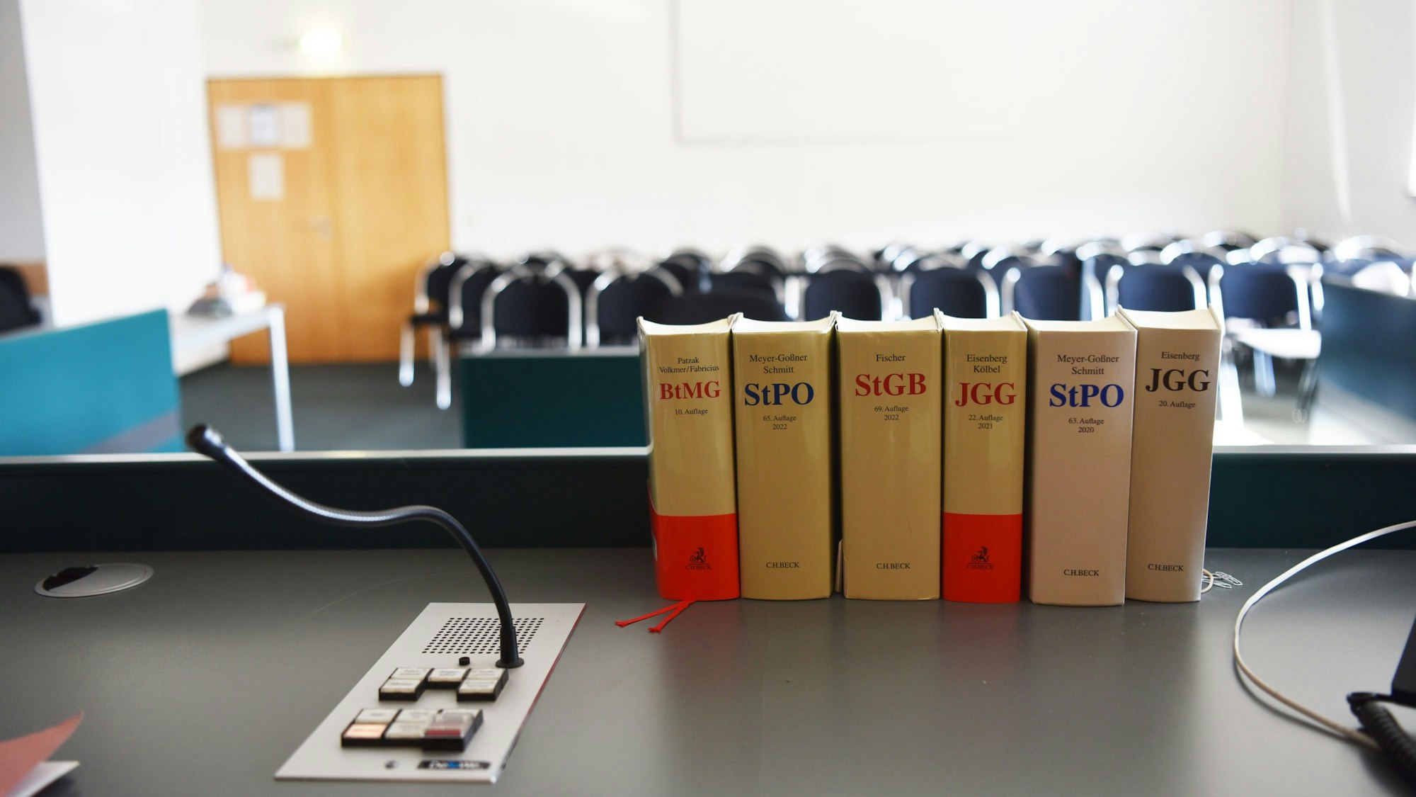 Gesetzesbücher stehen auf dem Tisch in einem Gerichtssaal.