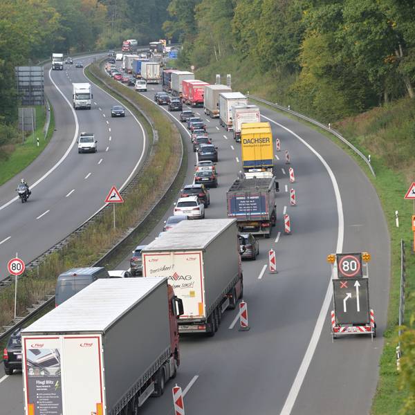 Lkws und Pkws stauen sich auf einer begrenzten Fahrbahn