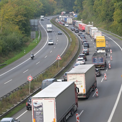 Lkws und Pkws stauen sich auf einer begrenzten Fahrbahn