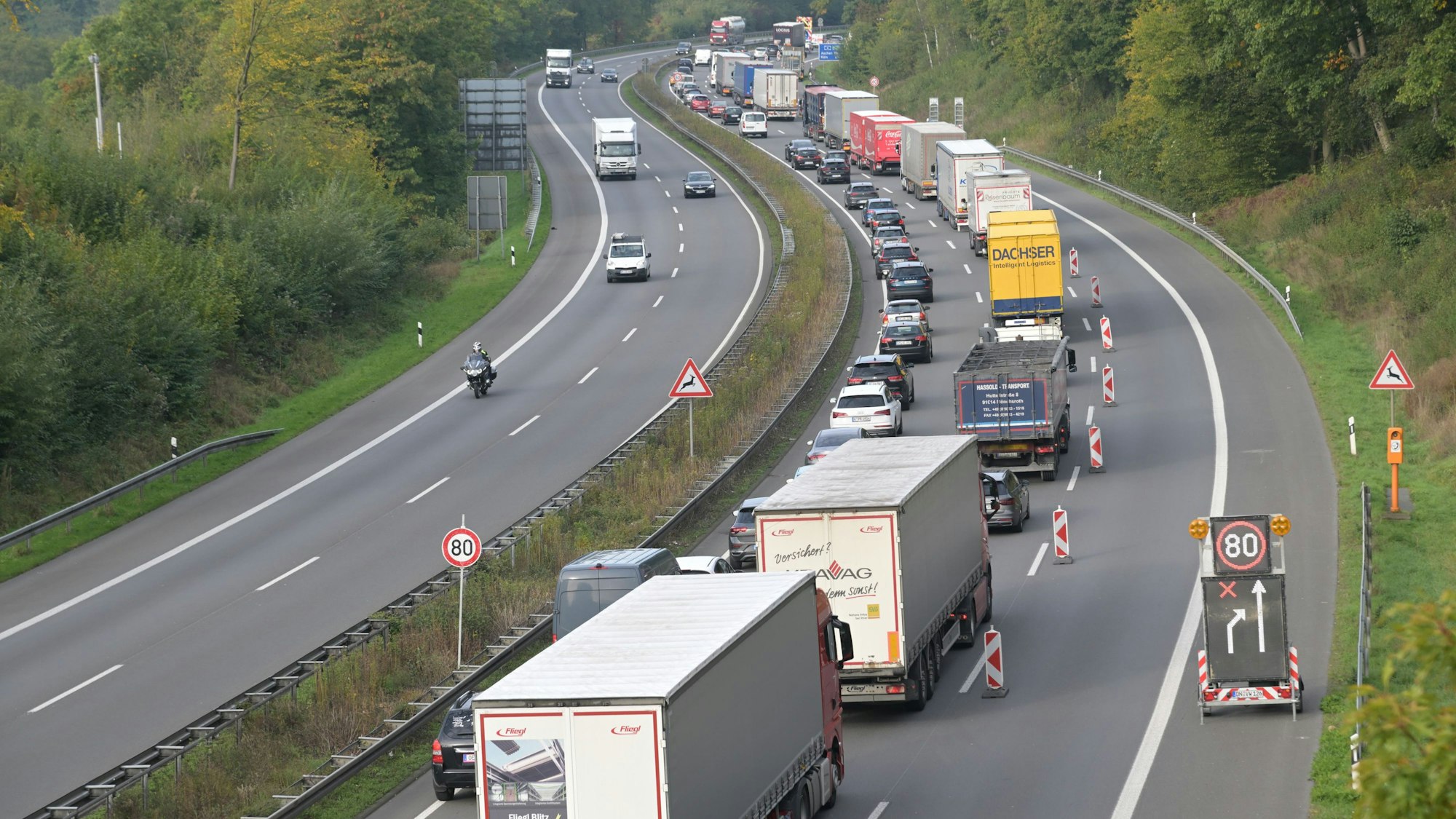 Lkws und Pkws stauen sich auf einer begrenzten Fahrbahn