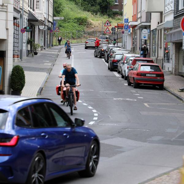 Die Laurentiusstraße in Bergisch Gladbach mit Fahrradfahrenden, Autos und Häusern.