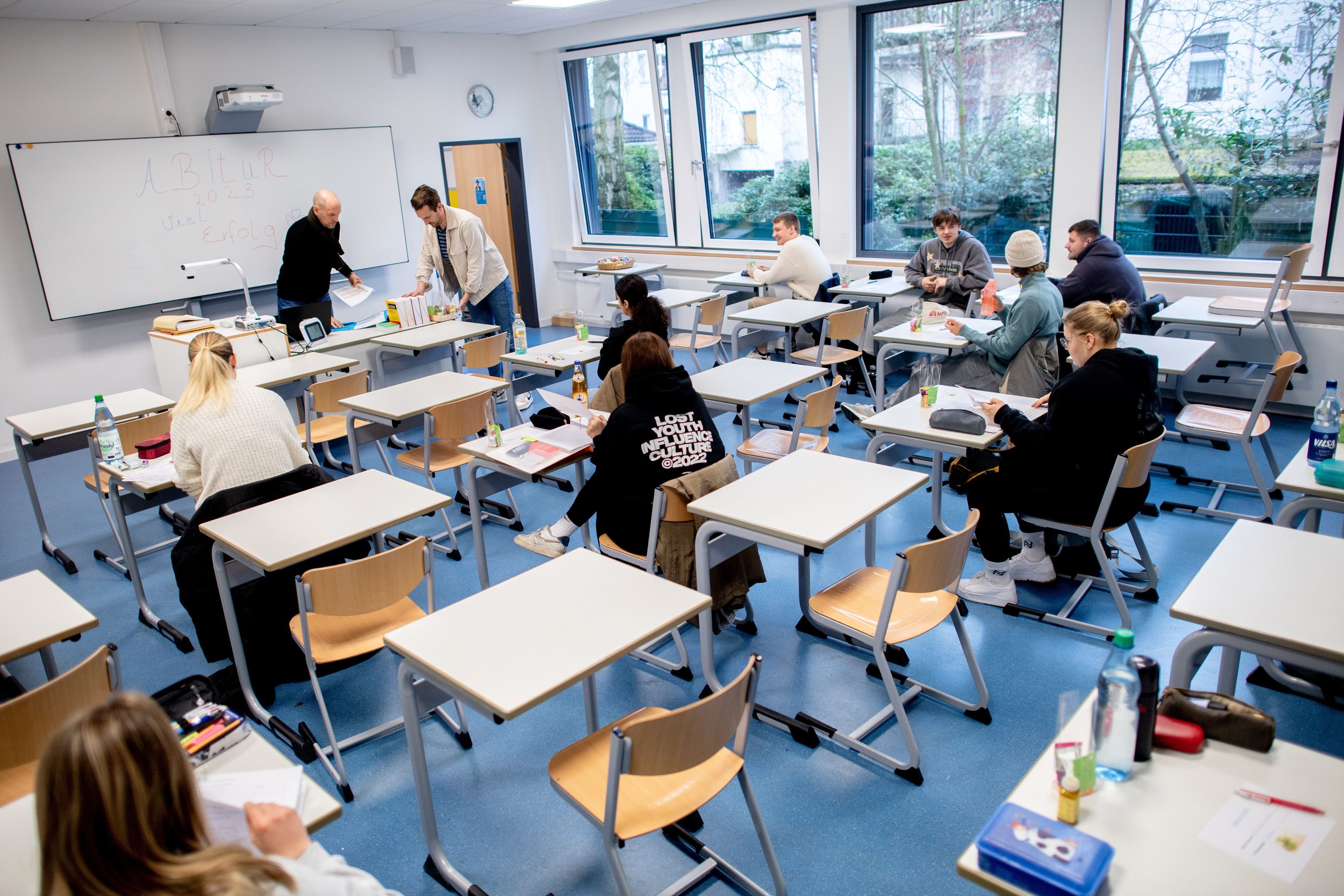 Schüler sitzen vor Beginn der schriftlichen Abiturprüfungen in einem Klassenraum.