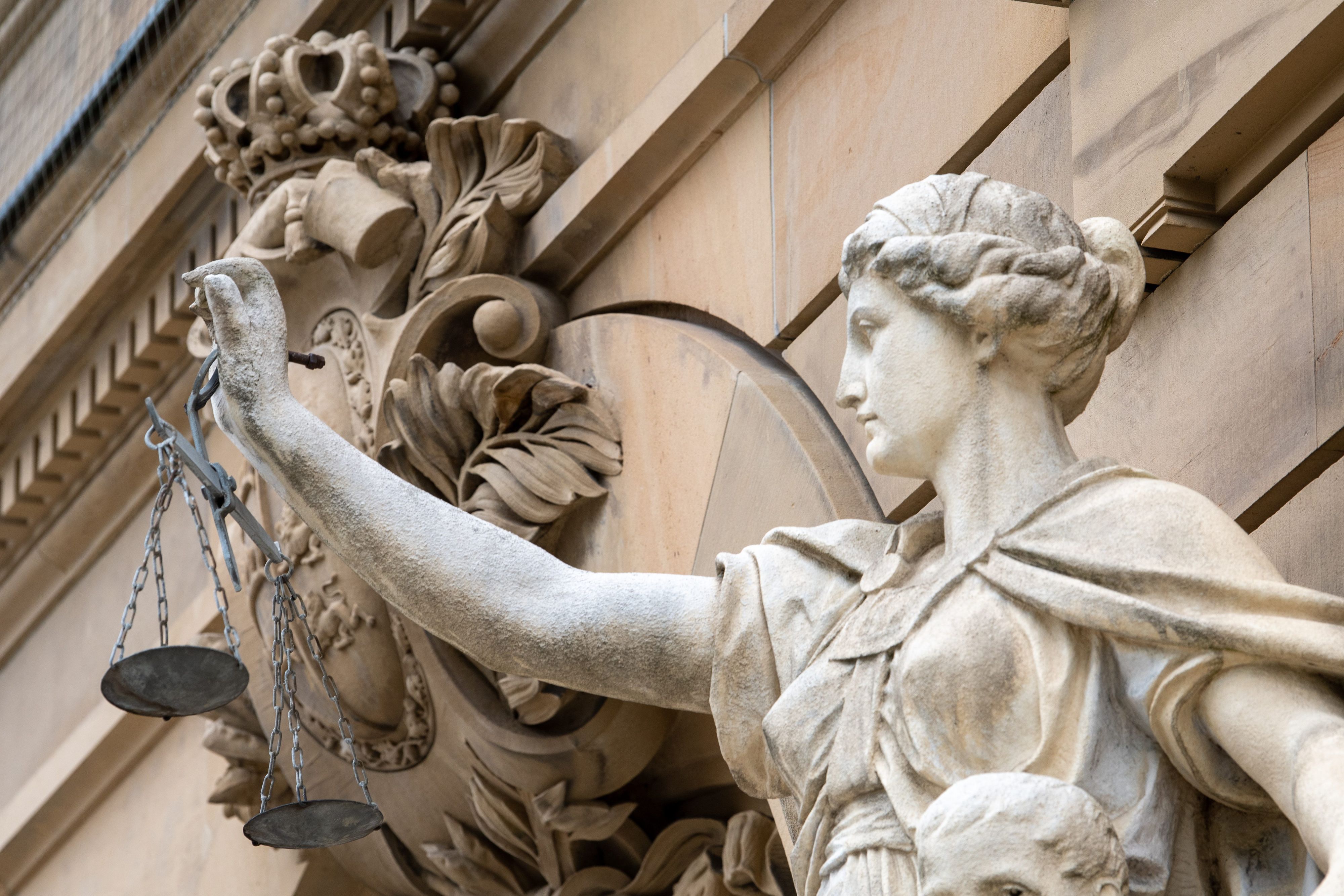 Vor dem Gebäude des Amt- und Landgerichts hält eine Statue der Göttin Justitia eine Waagschale.