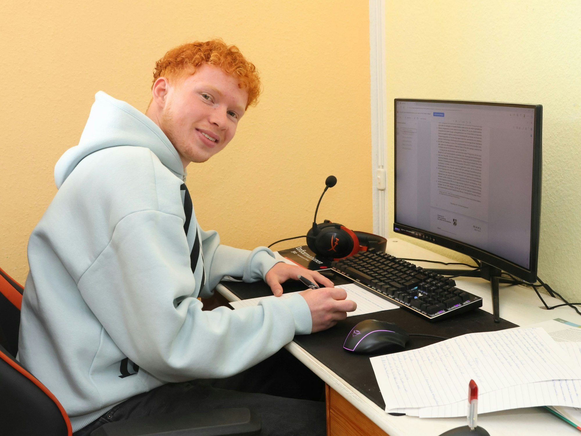 Der Wiehler Abiturient Adrian Großert sitzt vor seinen Lehrsachen am Schreibtisch.