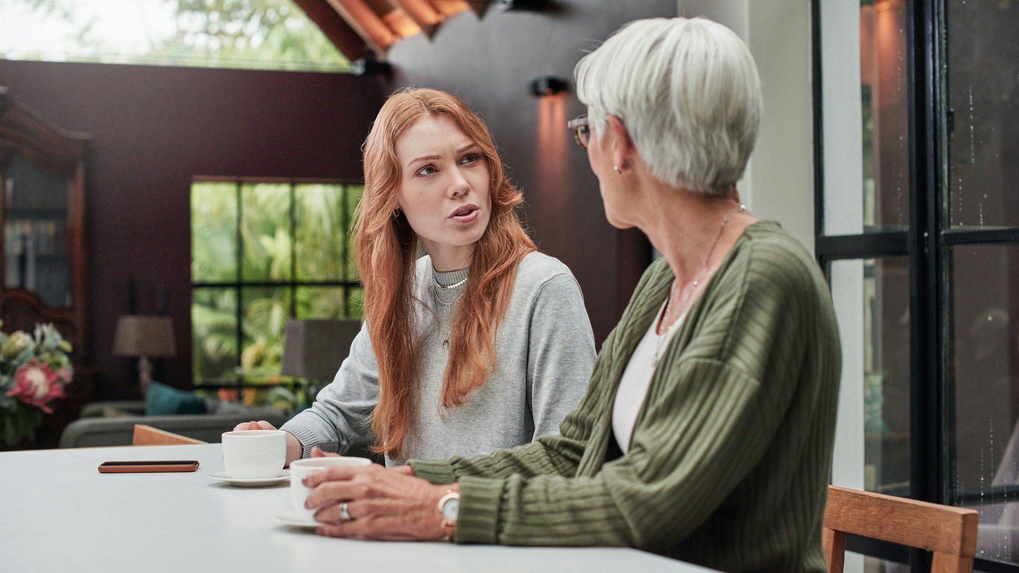 Erwachsene Tochter spricht mit ihrer Mutter ernst