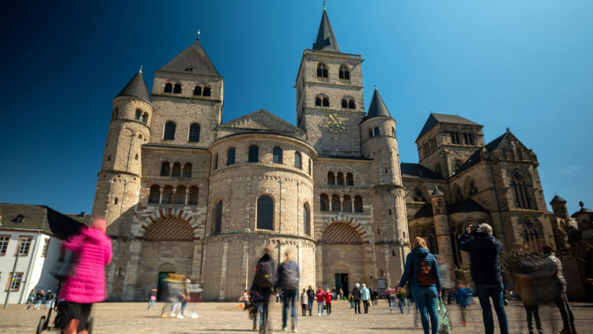Menschen gehen über den Domfreihof vor dem Dom.
