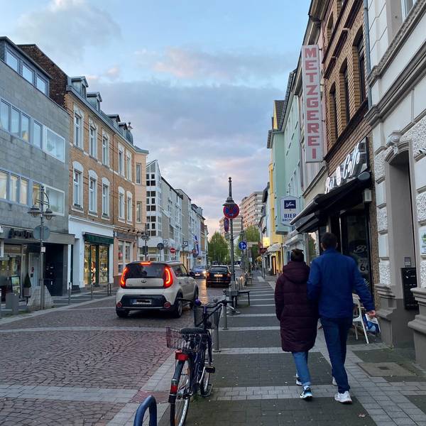 Das Foto zeigt die Kölnstraße in Brühl. Sie wird von mehreren Autos befahren, auf dem Bürgersteig gehen zwei Passanten.
