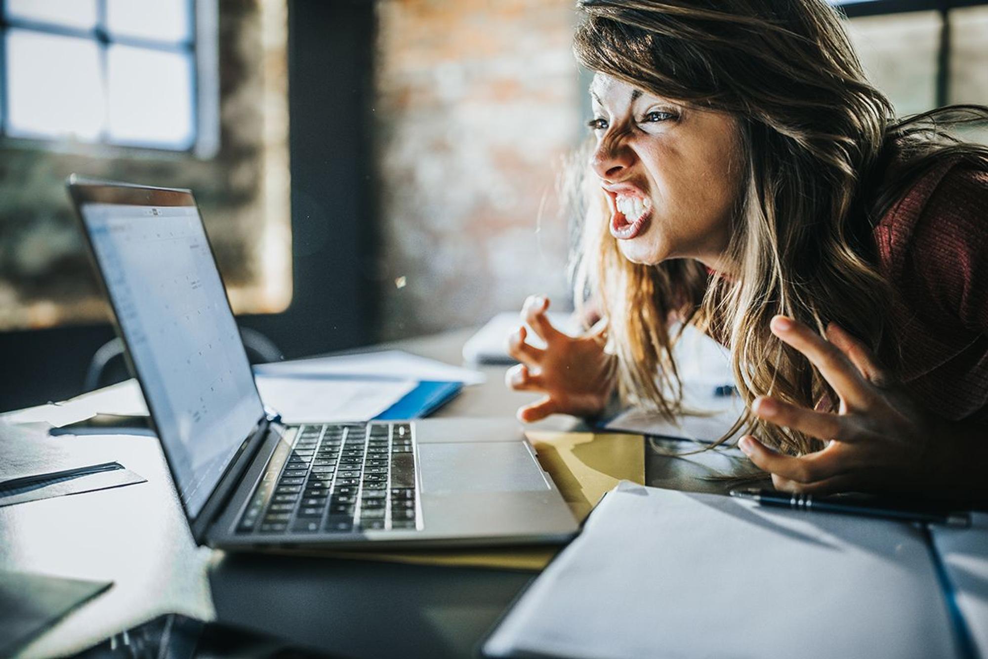Frau vor dem Laptop die sich aufregt