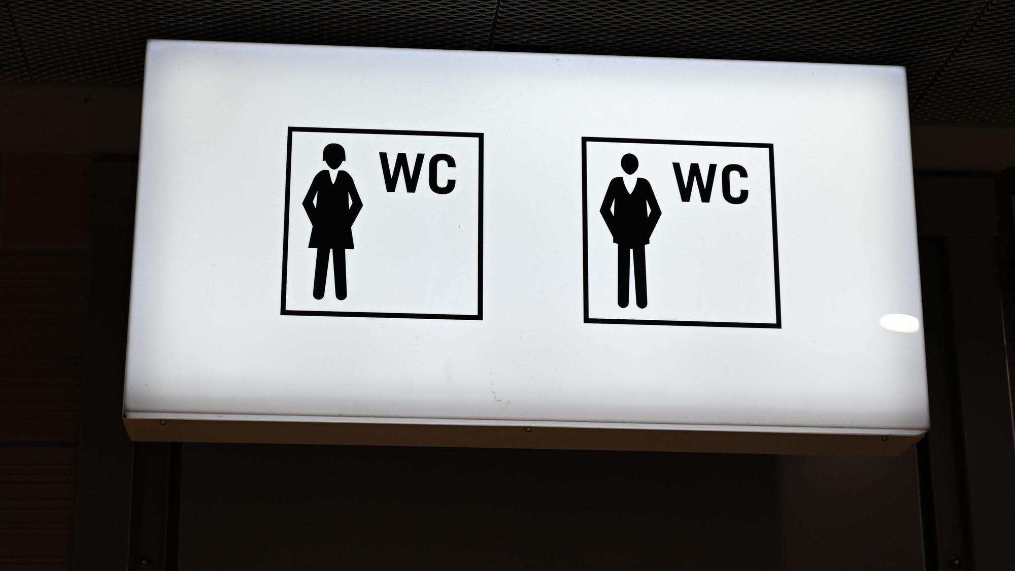 Ein beleuchtetes Hinweisschild mit Piktogrammen ist in der B-Ebene der Konstablerwache vor einem öffentlichen WC für Frauen und Männer angebracht.