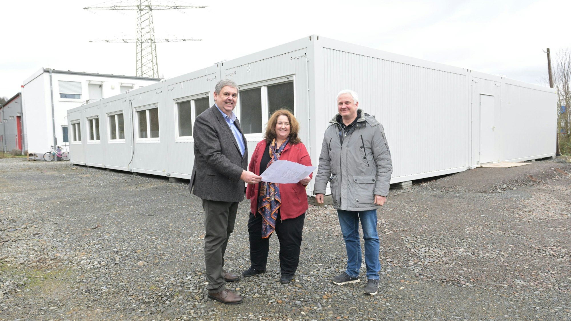 Bondina Schulze, Ulrich Kowalewski und Christian Thönelt stehen vor einer Asylunterkunft in Rösrath.