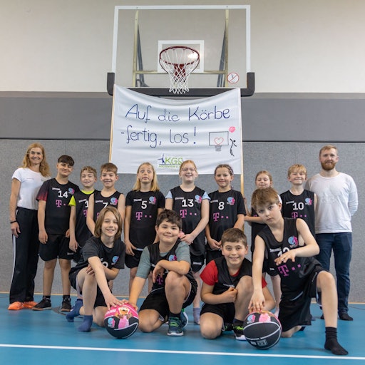 Die Sportlehrer Antje Rau und Daniel Miczka mit der Basketballmannschaft am 20.04.2023 bei der Vorstellung der neuen Trikots in der Katholischen Grundschule in Meckenheim. Foto Copyright: Petra Reuter