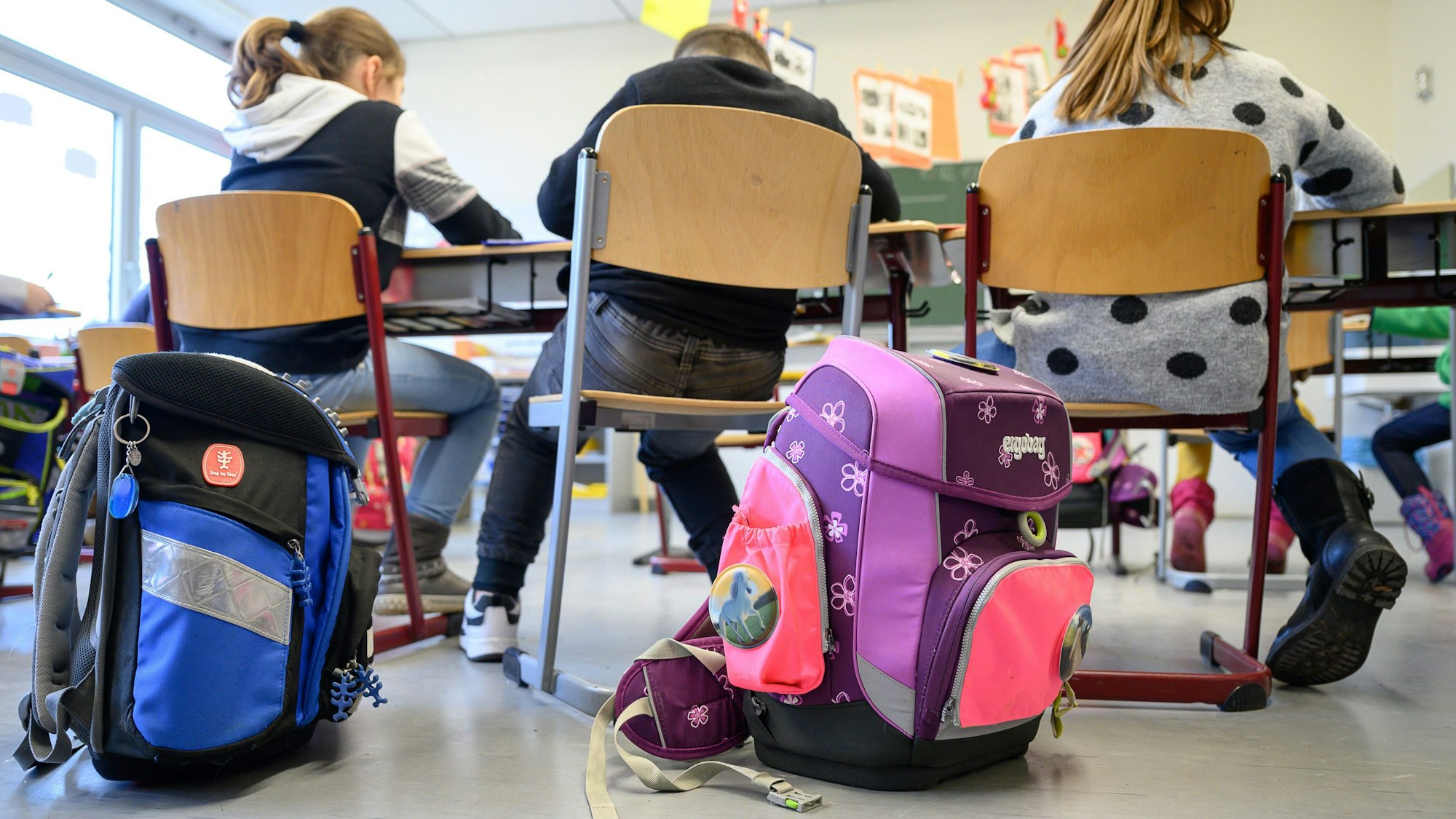 Schulranzen stehen in einer Grundschule.