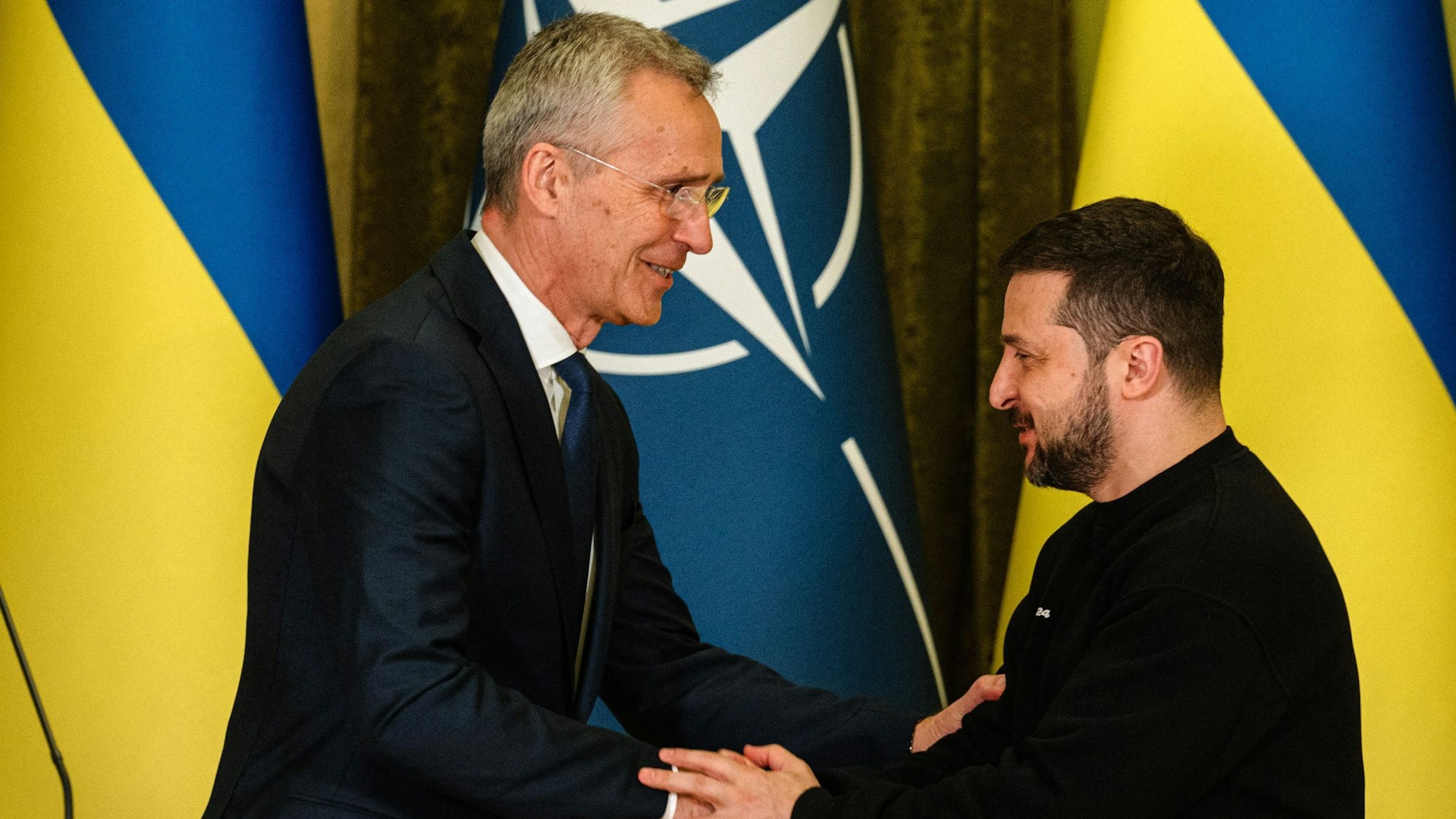 Jens Stoltenberg schüttelt Wolodymyr Selenskyj die Hand.