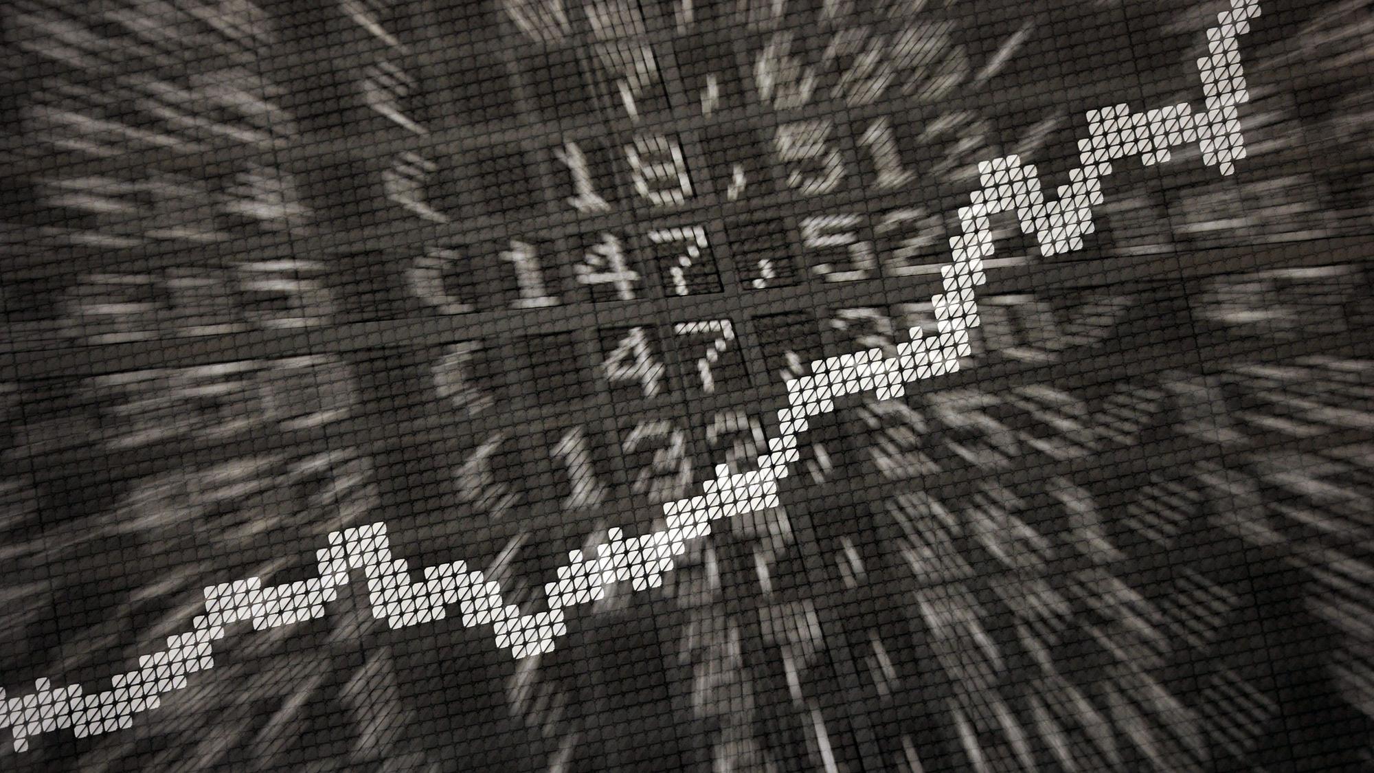 Die große Anzeige in der Börse zeigt die Dax-Kurve und verschiedene Börsenkurse (Aufnahme mit Doppelbelichtung).