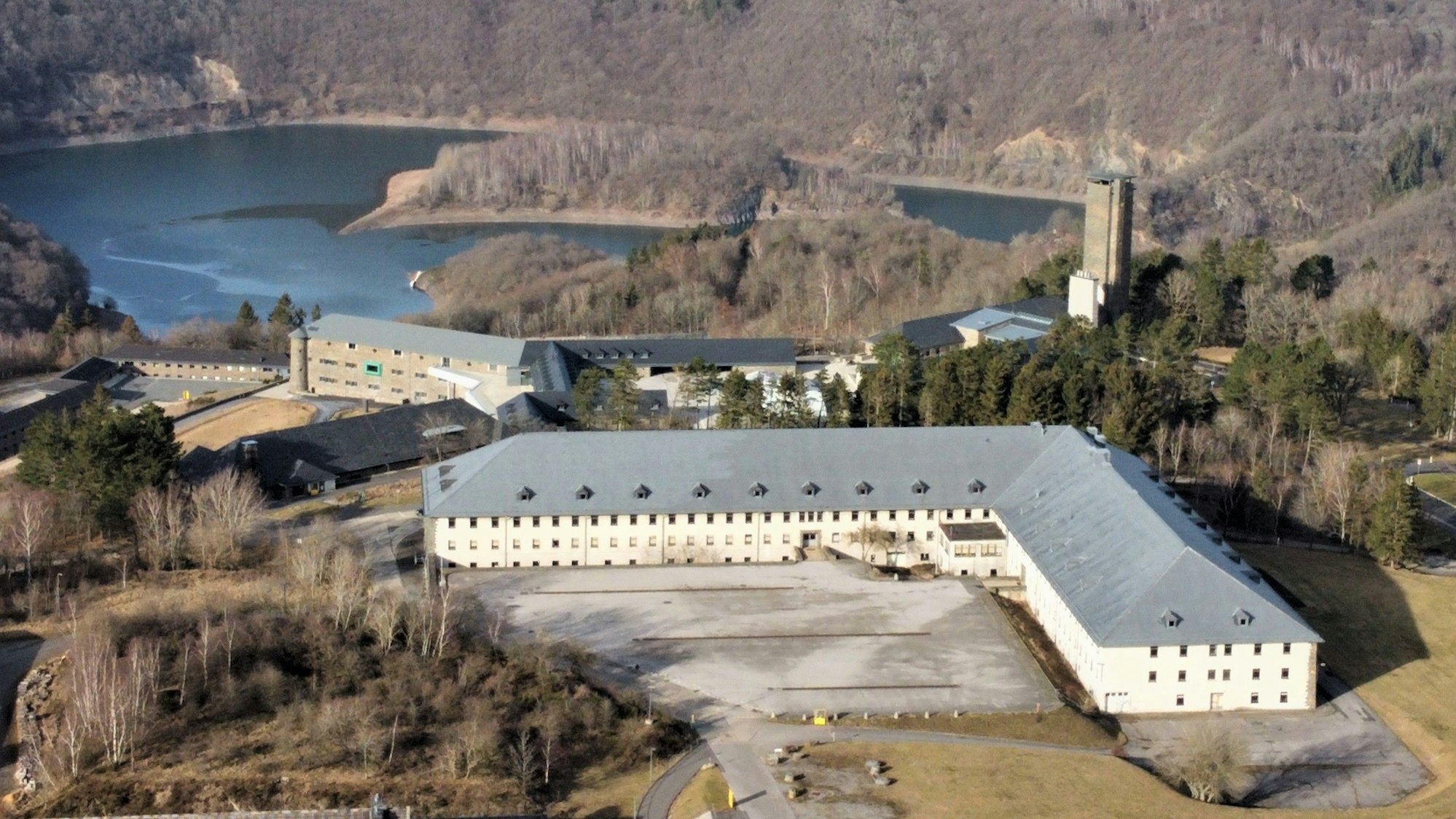 Drohnenaufnahme von Van Dooren mit dem Urftsee im Hintergrund.