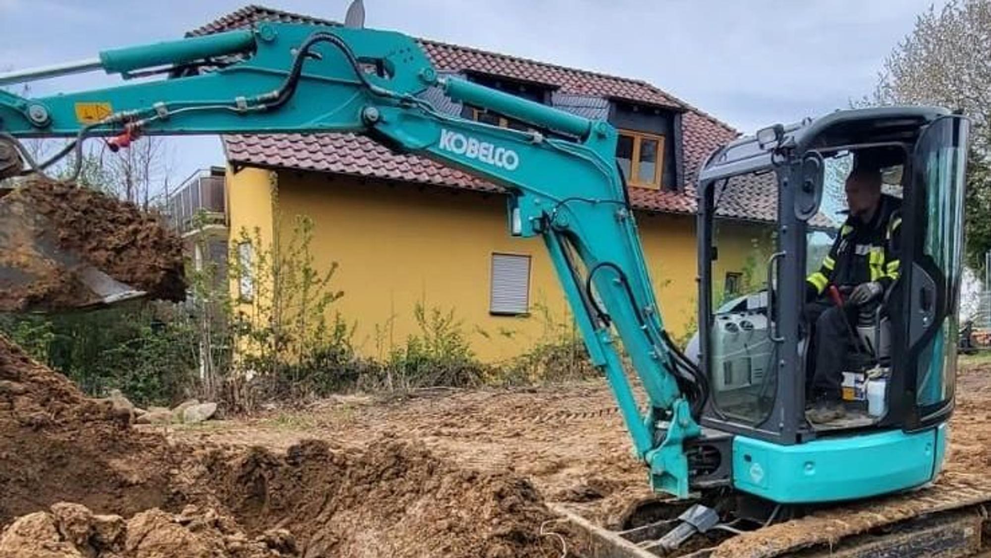Ein Mann sitzt am Steuer eines Baggers.
