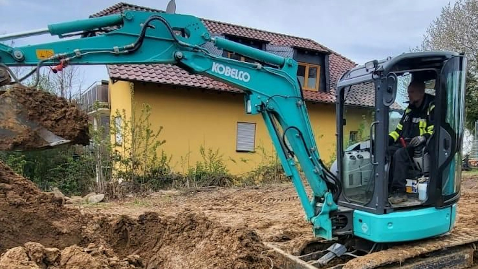 Ein Mann sitzt am Steuer eines Baggers.