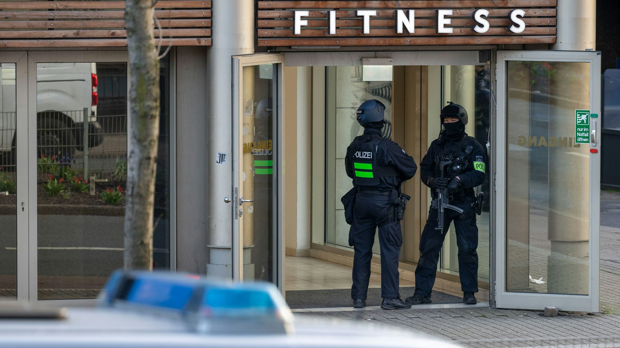 Polizisten sind in Duisburg im Einsatz. Sie stehen vor dem Fitnessstudio, in dem bei einer Attacke mehrere Personen schwer verletzt wurden.