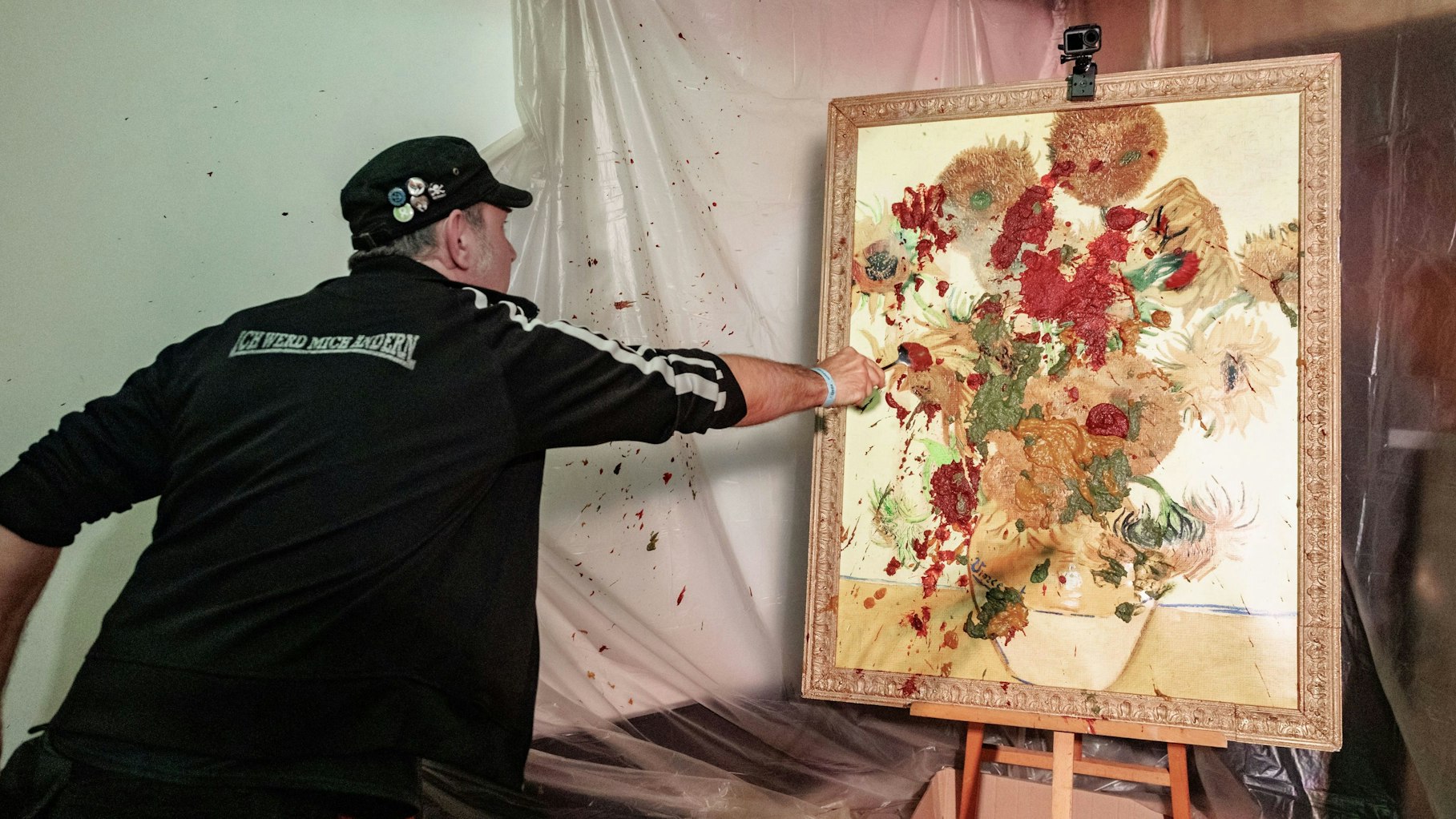 TV-Koch Ole Plogstedt wirft im St. Pauli Museum Brei auf ein Bild.