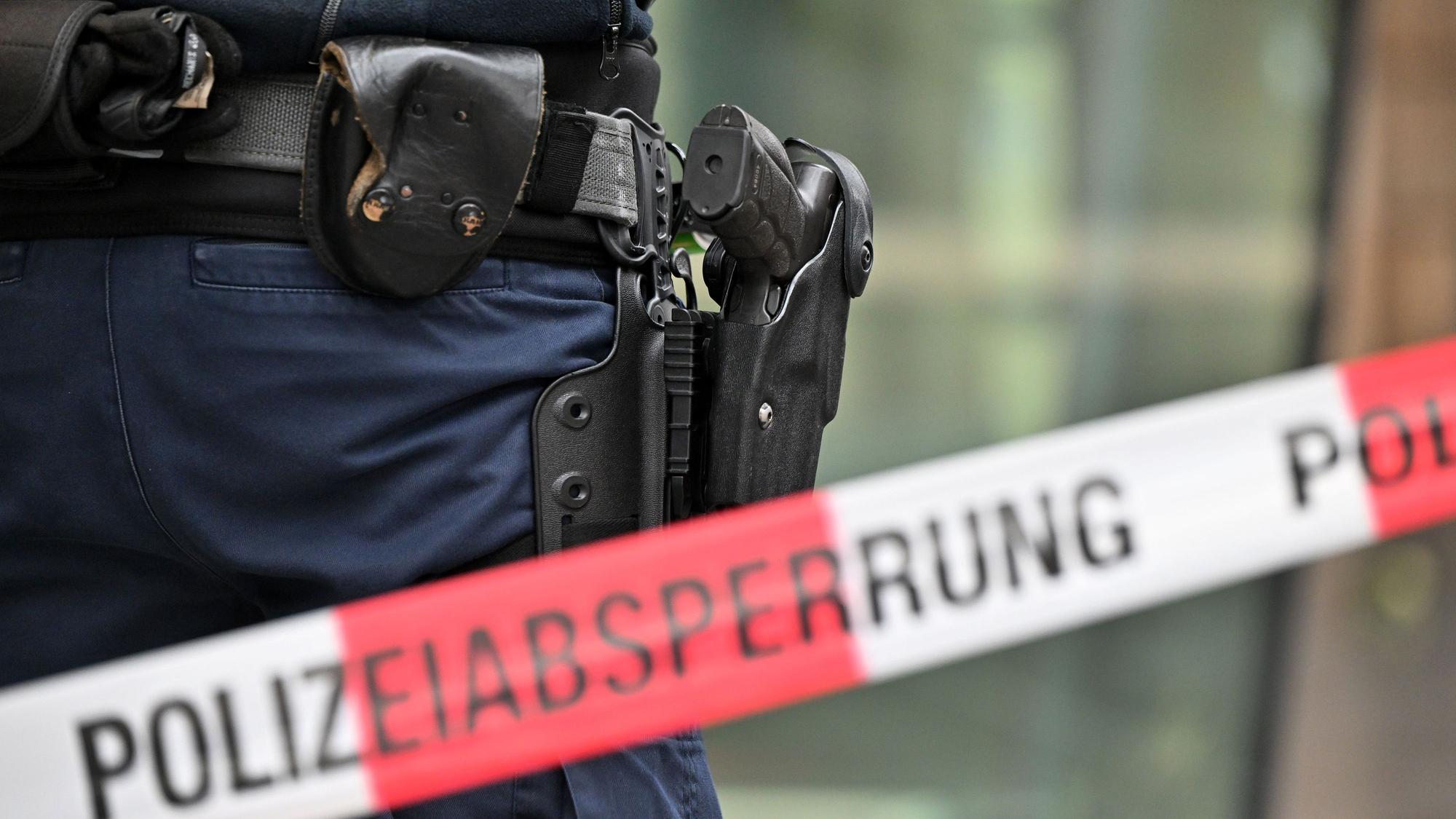Bewaffnete Bundespolizisten stehen an einer Polizeiabsperrung.