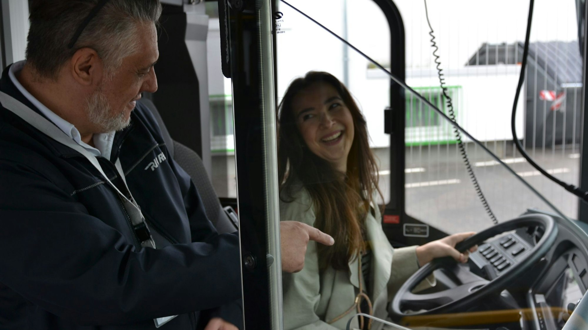 Eine junge Frau sitzt am Steuer eines Busses.