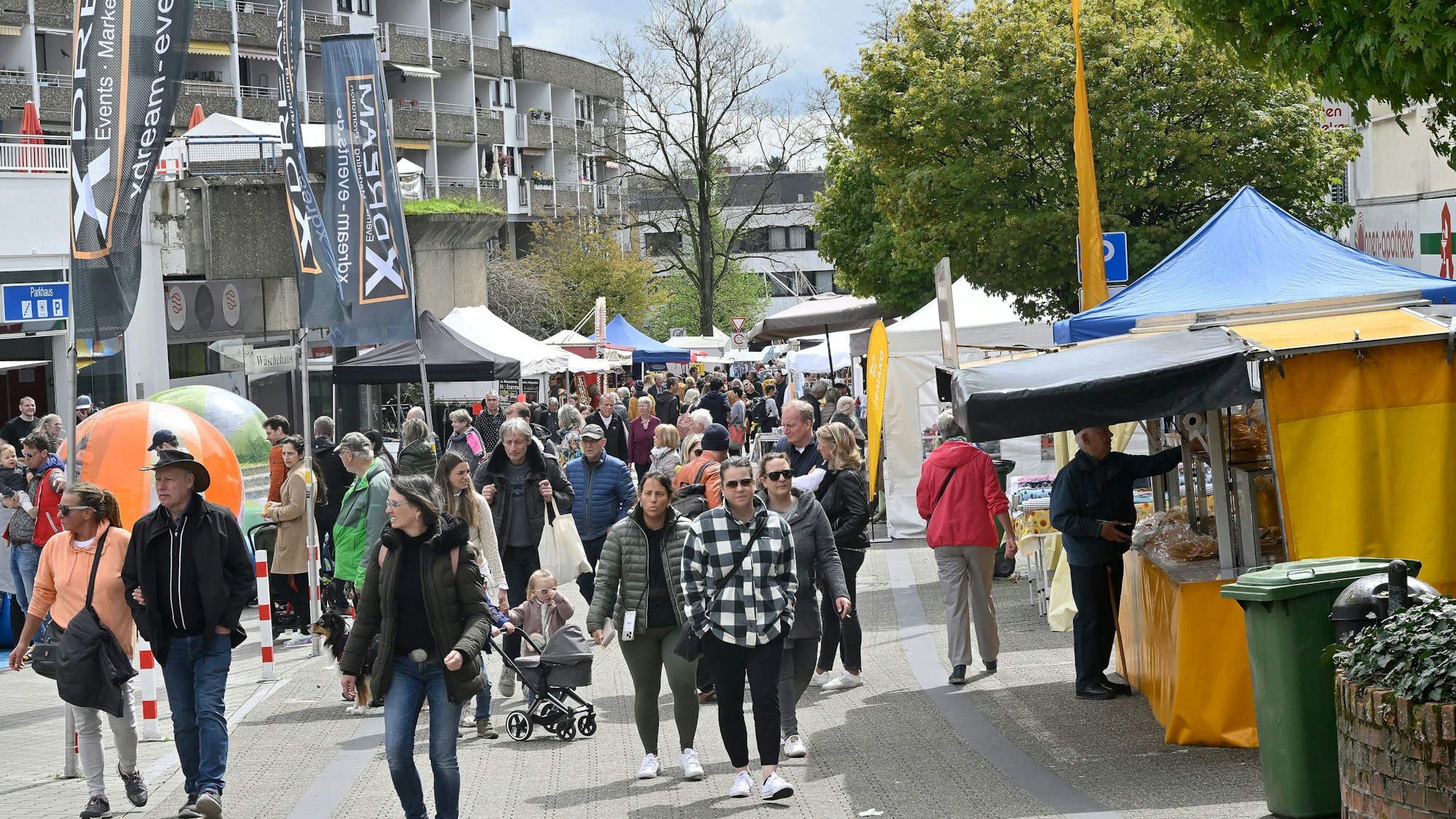 Viele Menschen flanieren über die Straße, am Straßenrand sind Verkaufsbuden aufgestellt.