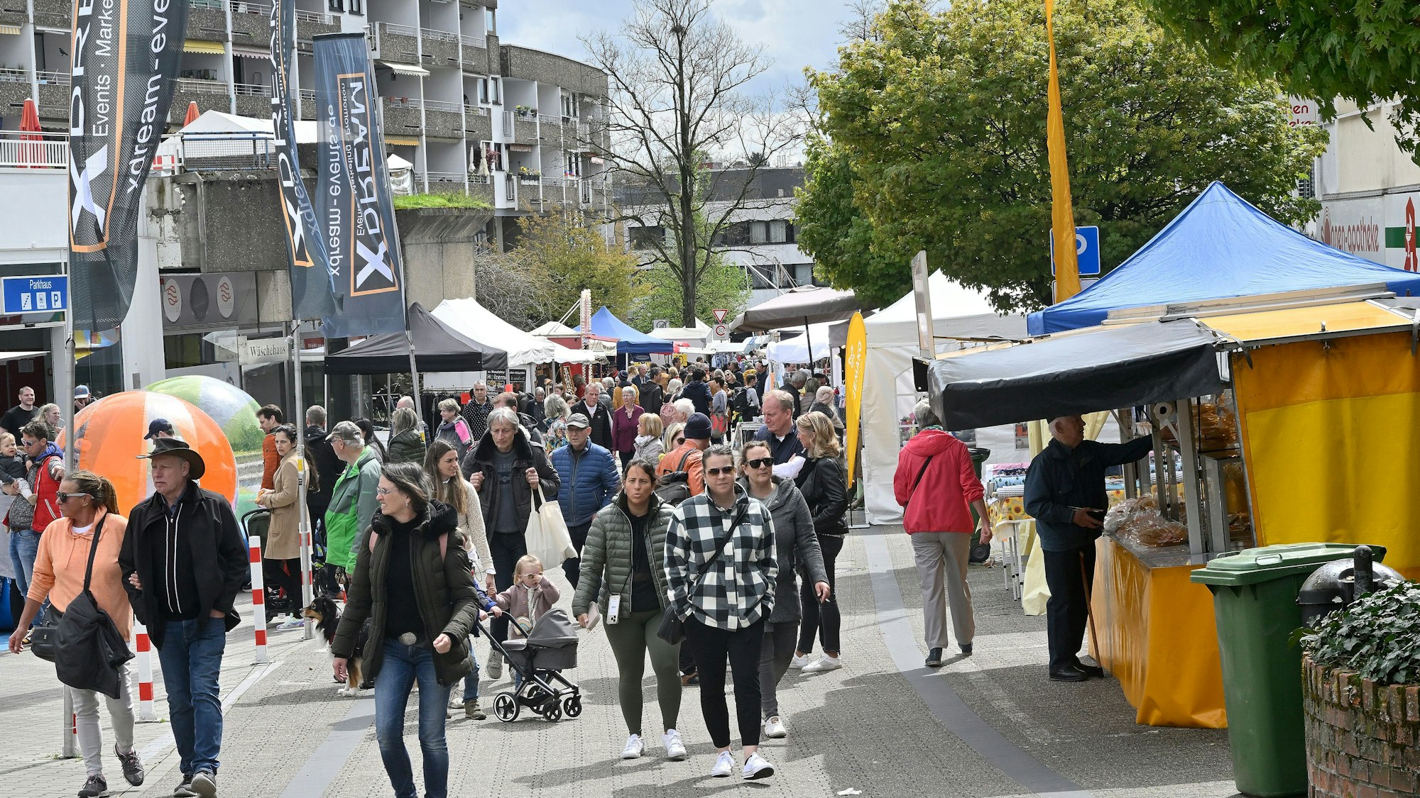Viele Menschen flanieren über die Straße, am Straßenrand sind Verkaufsbuden aufgestellt.
