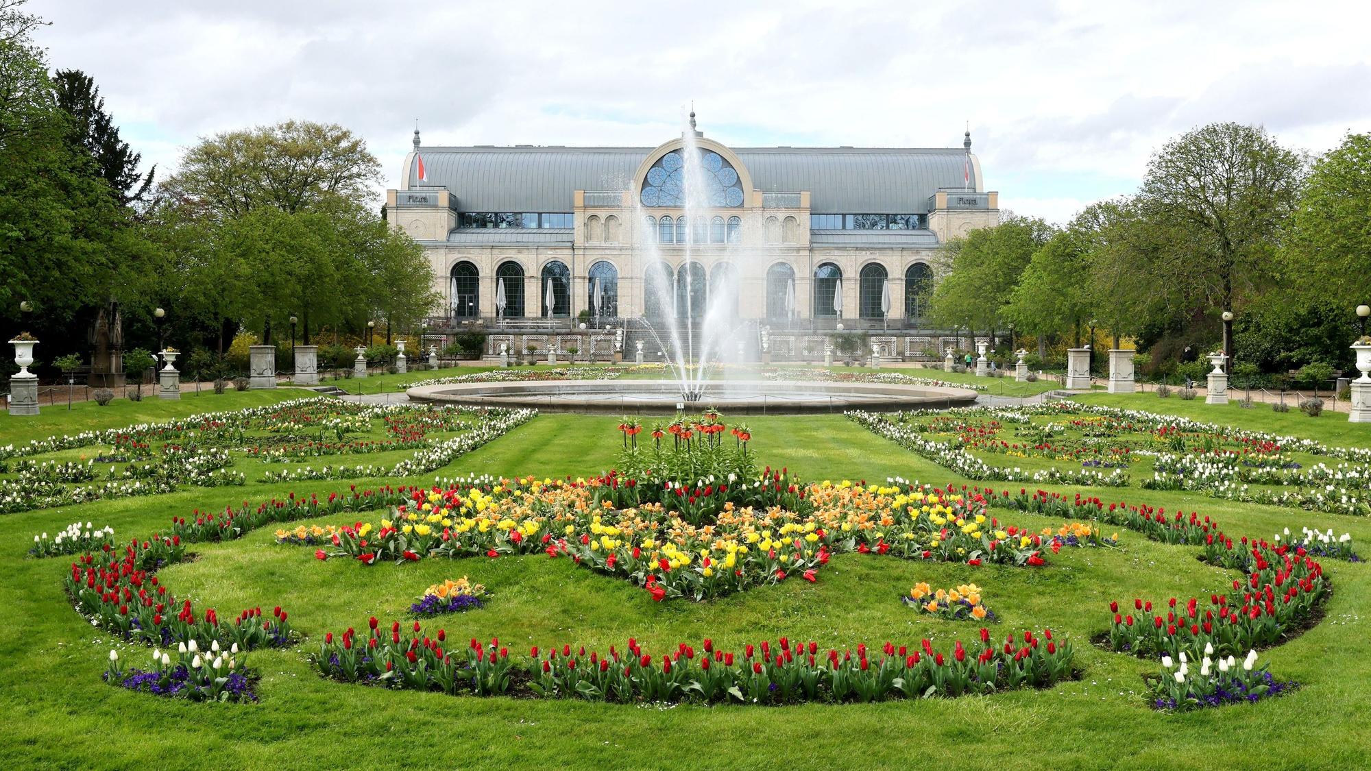 Die Flora in Köln, im Hintergrund der Glaspalast, der Springbrunnen sprudelt.