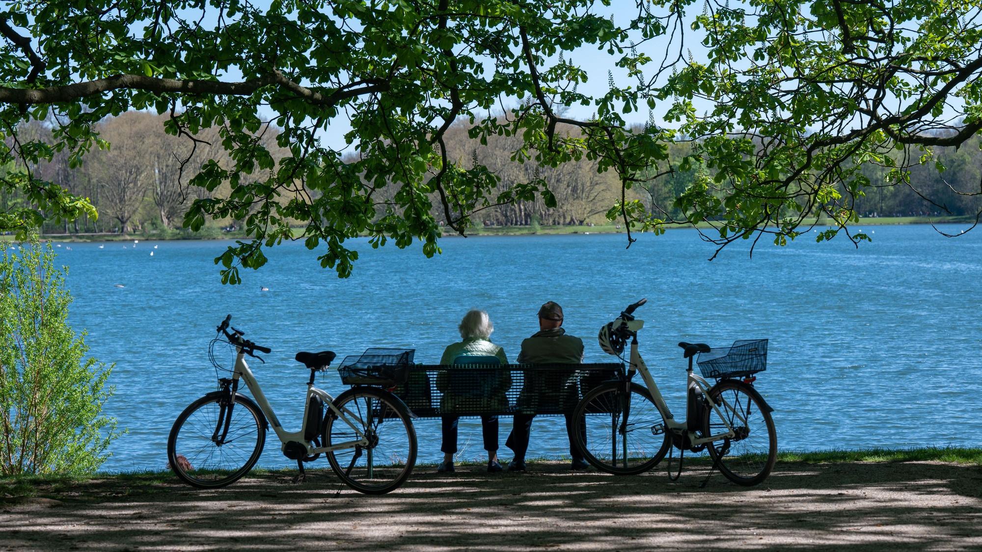 Ein Paar sitzt auf einer Bank mit Blick auf den Decksteiner See in Köln