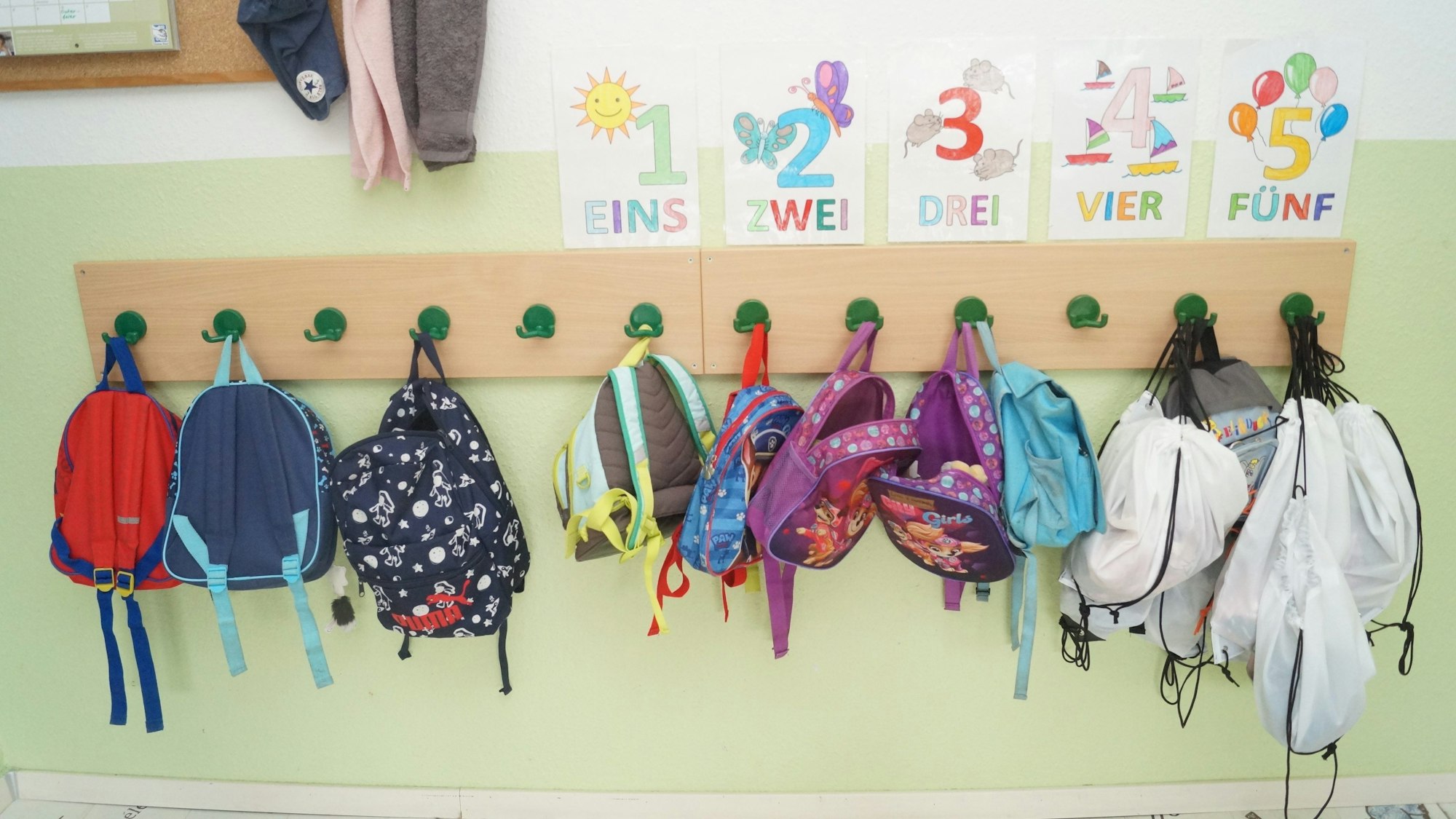 Rucksäcke hängen in einer Kita an einer Gaderobe. (Symbolbild)