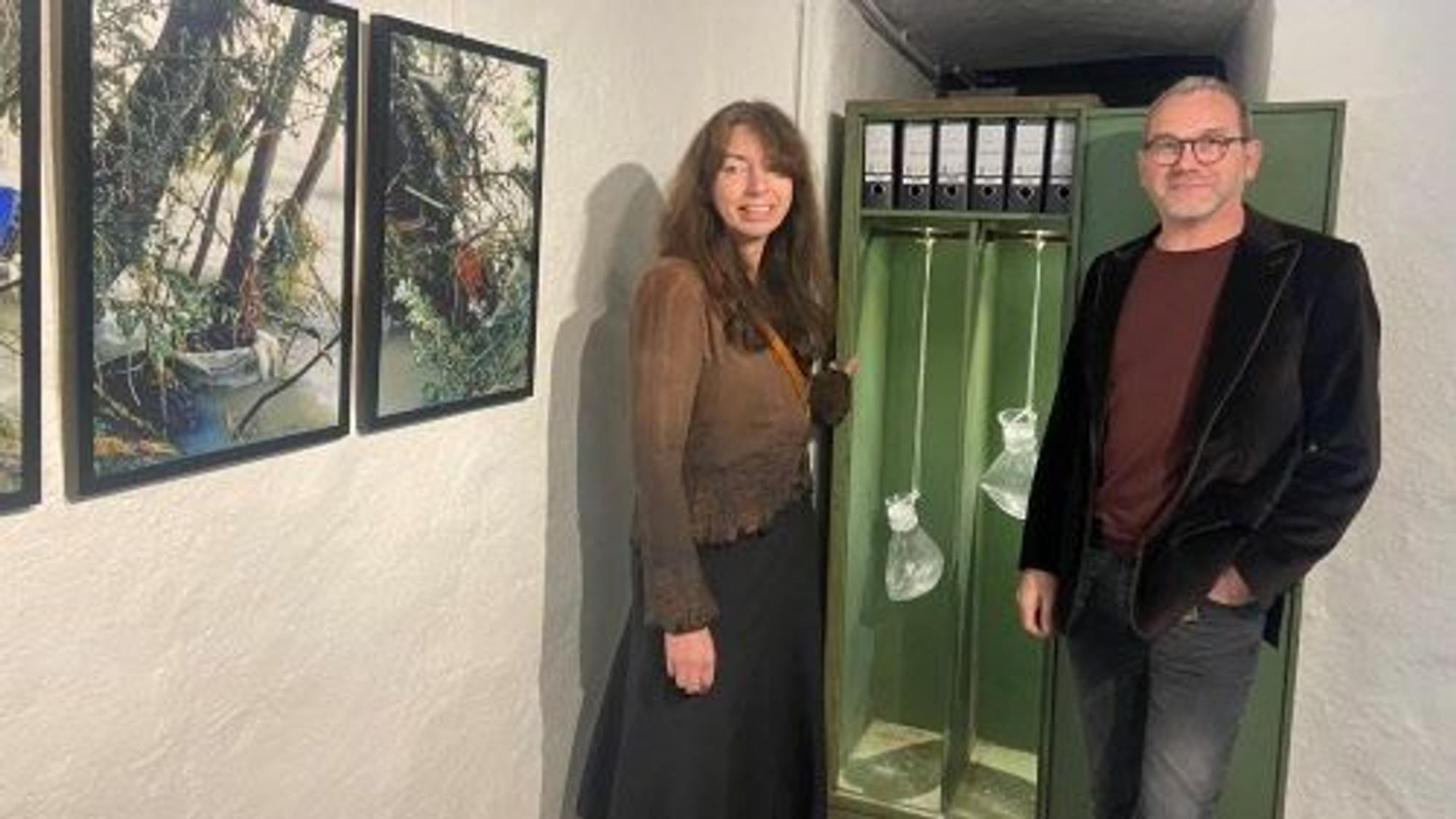 Zündorfer Wehrturm Wasser-Ausstellung, ein Mann und eine Frau stehen vor einem geöffneten Aktenschrank, in dem Wasserbeutel hängen