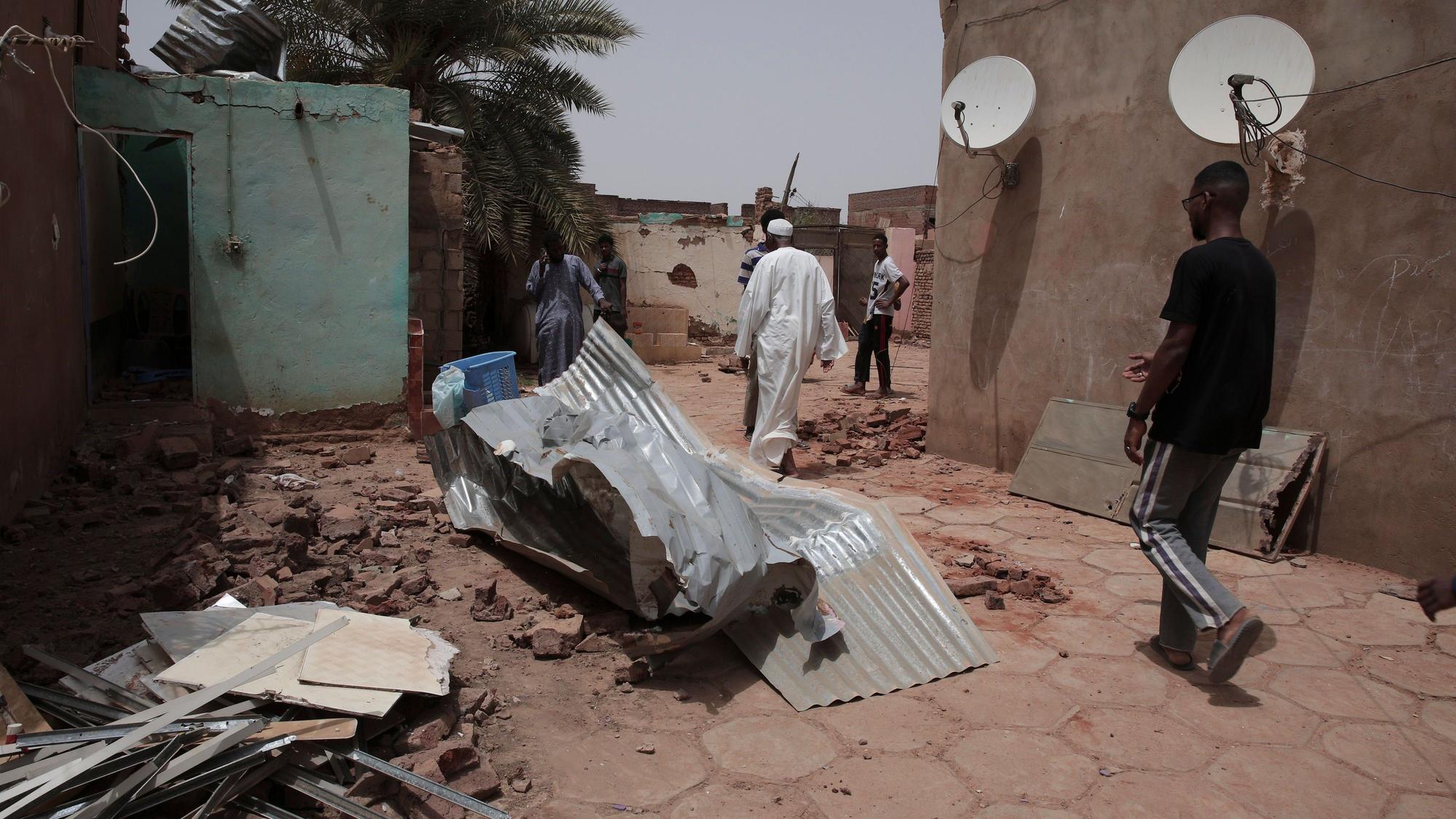 25.04.2023, Sudan, Khartum: Menschen gehen an einem Haus vorbei, das bei den jüngsten Kämpfen beschädigt wurde.