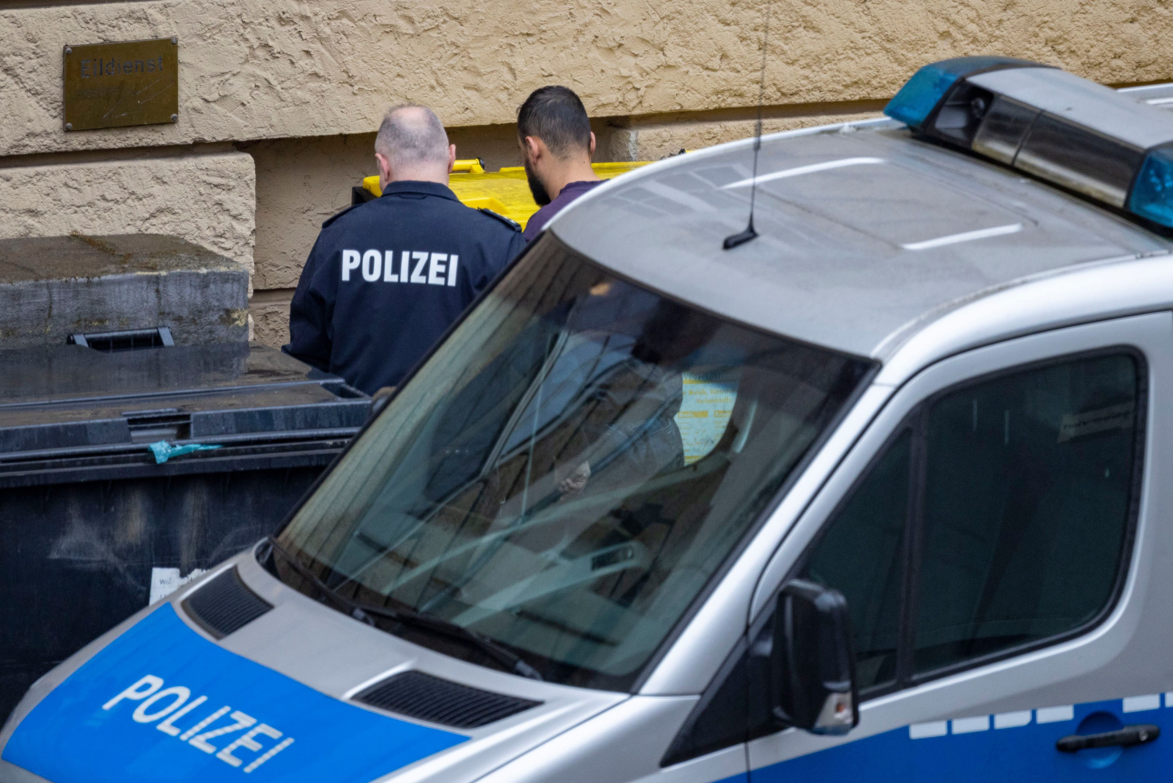 Ein Polizist führt den Tatverdächtigen des Angriffs in einem Duisburger Fitnessstudio in ein Gerichtsgebäude.