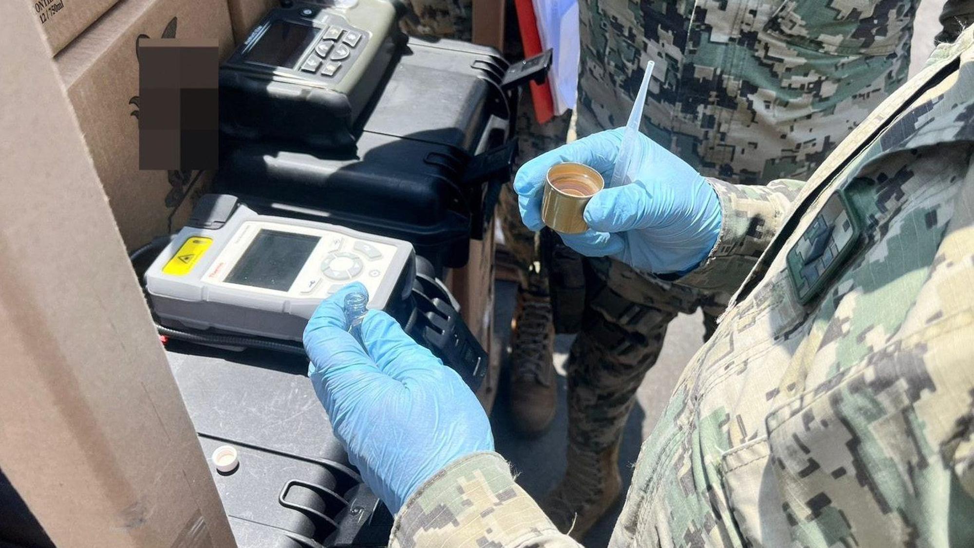 Ein mexikanischer Marinesoldat nimmt eine Probe aus einer sichergestellten Tequila-Flasche im mexikanischen Pazifikhafen Manzanillo.