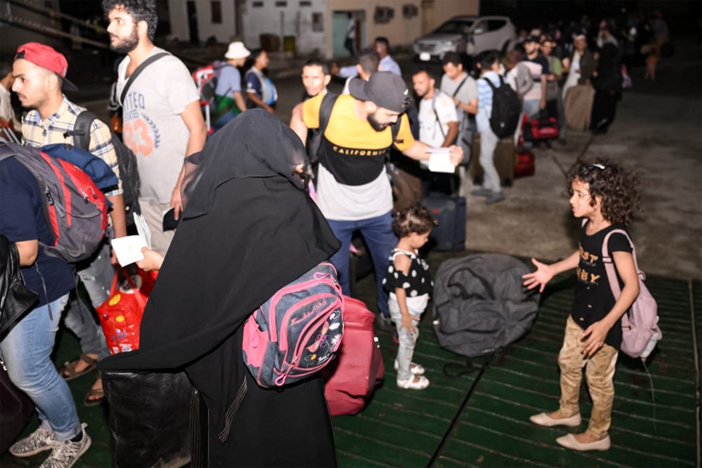 Menschen warten in der Schlange vor einer Passagierfähre in Port, um evakuiert zu werden.