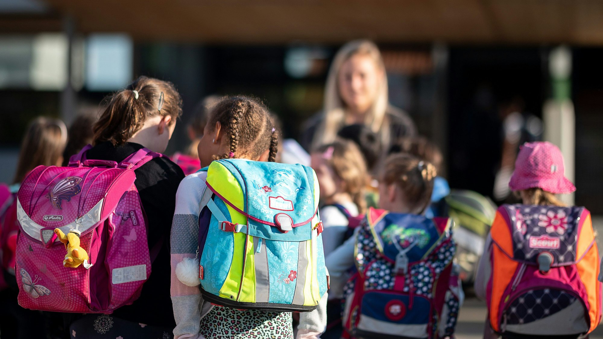 Kinder stehen in einer Grundschule auf dem Hof
