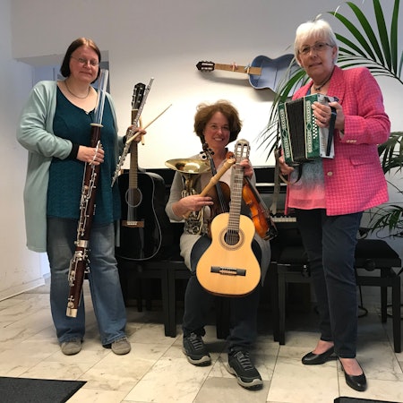 Drei Frauen mit Musikinstrumenten.